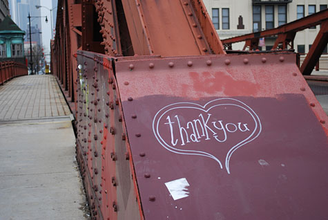 graffiti -- "thank you" inside a heart, drawn on the metal of a bridge 