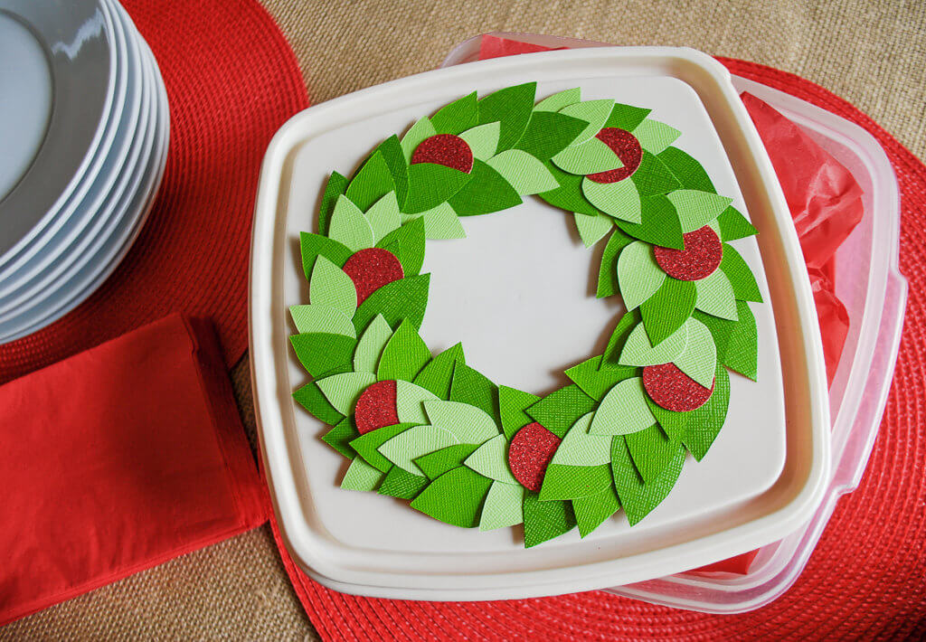 DIY holiday wreath decoration for food storage container lids. You spent all that time baking for holiday parties and Christmas cookie exchanges, so why put your goodies into plain storage containers?