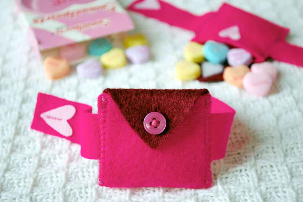 DIY Valentine’s Day Felt Heart Pocket Bracelet. Easy to sew by hand or on a sewing machine. The heart-shaped pocket holds candies or a teeny love note. Make this Valentine's Day gift for the sweet kid in your life! #valentinesday #valentine #felt #sewing