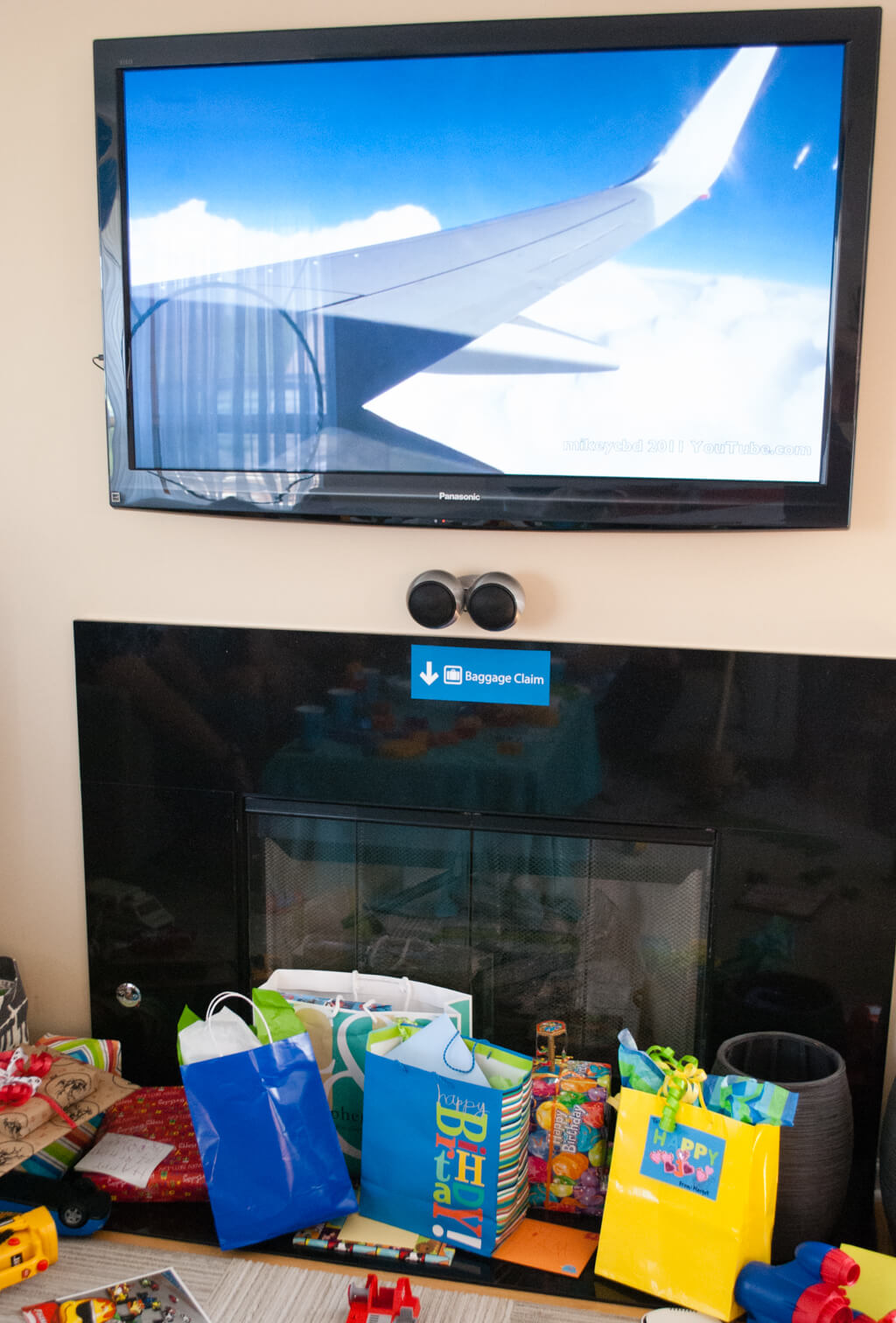 We put a baggage claim sign below the TV (looping an airplane video) for guests to drop off birthday presents