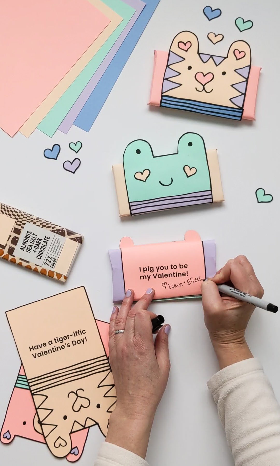 Writing names on the backs of chocolate bar wrappers for Valentine's Day gifts