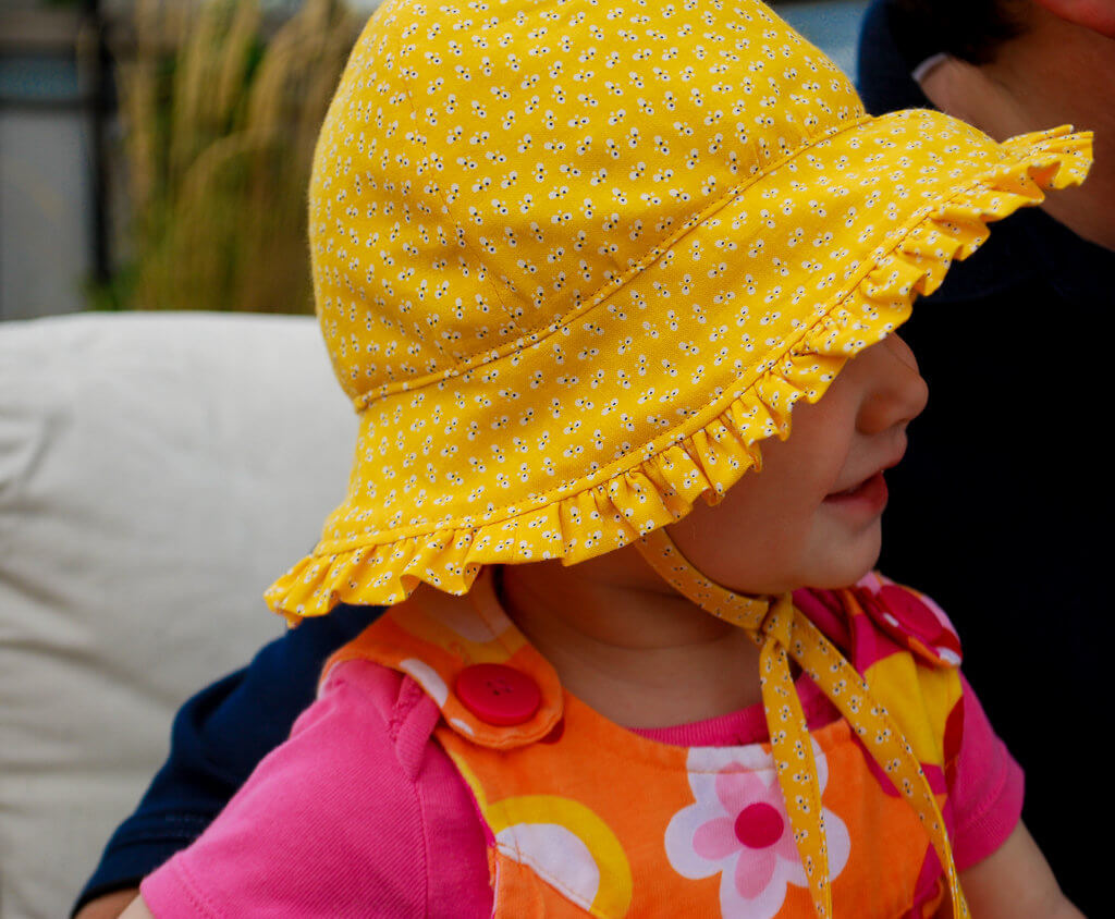 Baby sunhat hat free sewing pattern with ruffles and ties. Follow the step-by-step DIY tutorial to make a super cute baby hat.