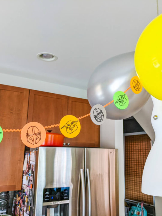 DIY Mandalorian party decorations - paper garland with Baby Yoda and the Mandalorian helmet