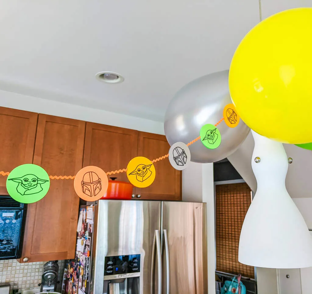 DIY Mandalorian party decorations - paper garland with Baby Yoda and the Mandalorian helmet