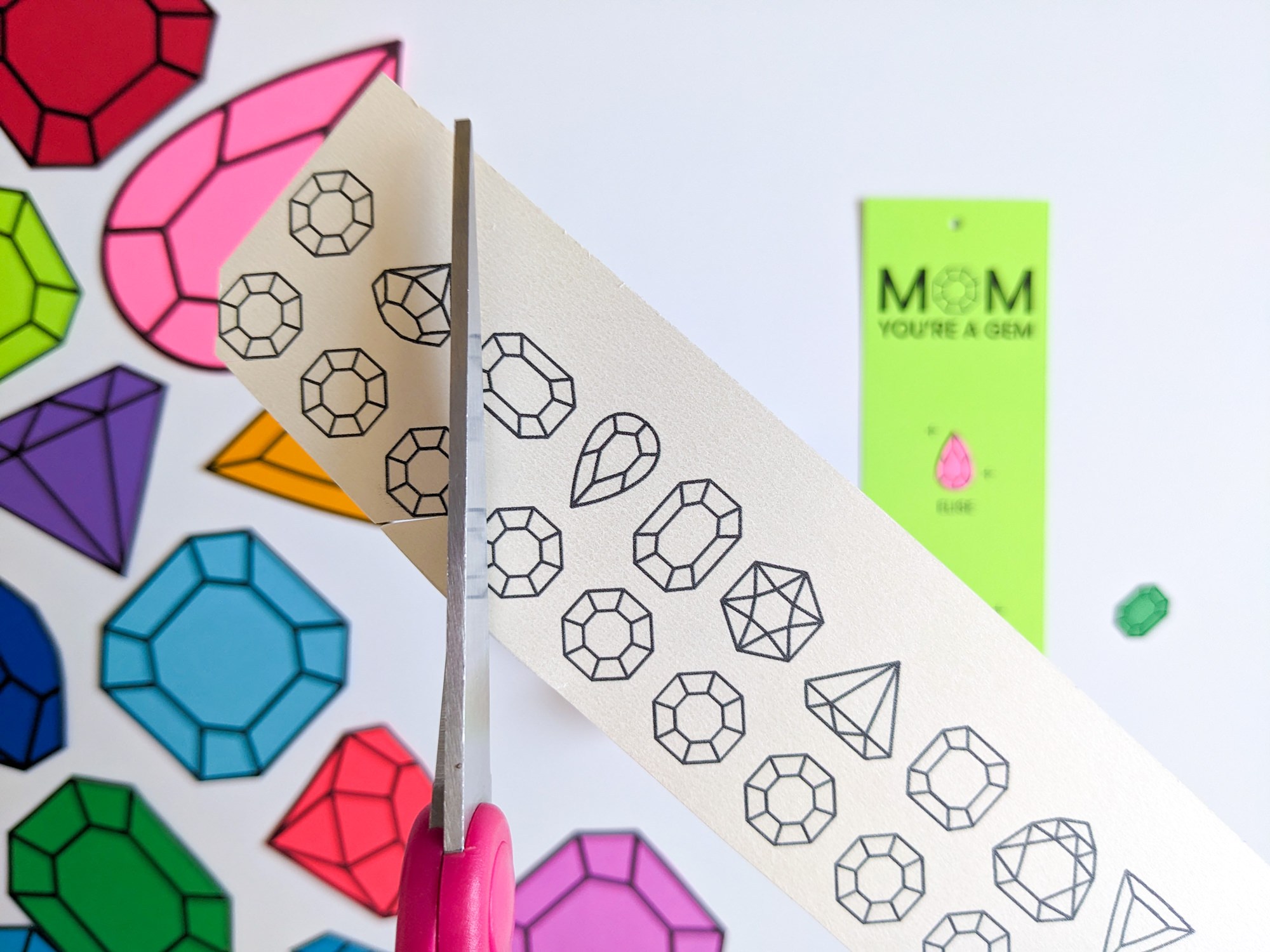 Cutting out paper gems with scissors to make DIY birthstone gifts for mom and grandma