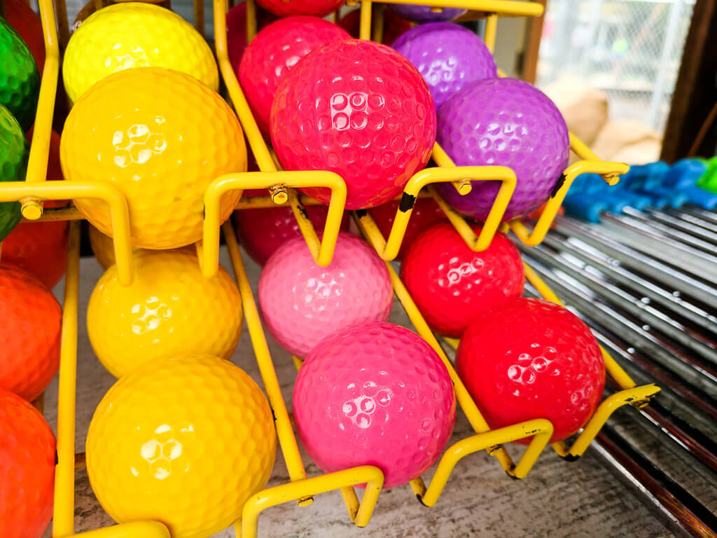 Yellow and pink and purple miniature golf balls