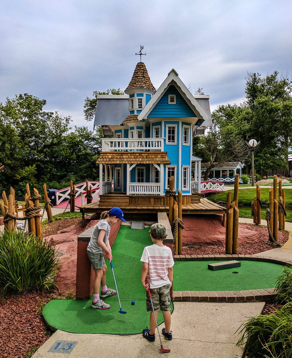 Kids playing miniature golf by Merriment Design