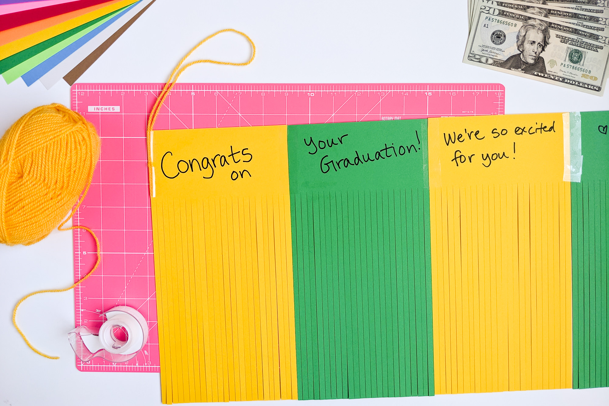 Writing a hidden message inside paper tassels that graduates will see when they unroll their money gift