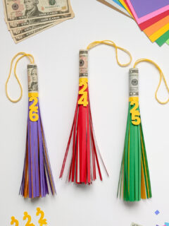 Three big paper graduation tassels with cash rolled inside for a money graduation gift