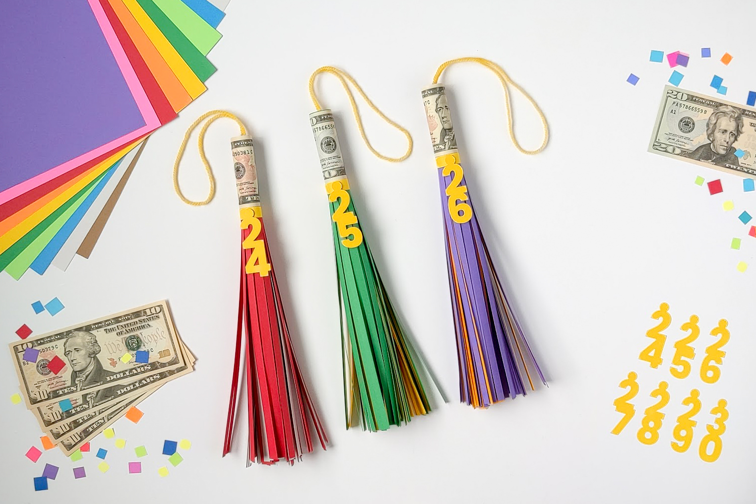 Three big paper graduation tassels with cash rolled inside for a money graduation gift