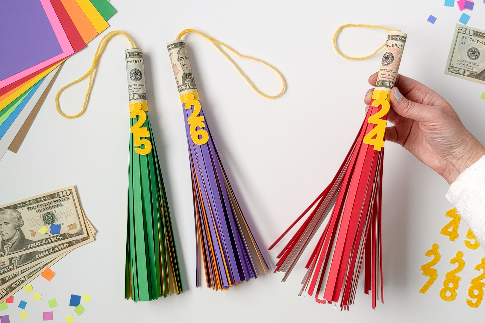 Cash rolled on the top of paper graduation tassels as a DIY graduation gift idea