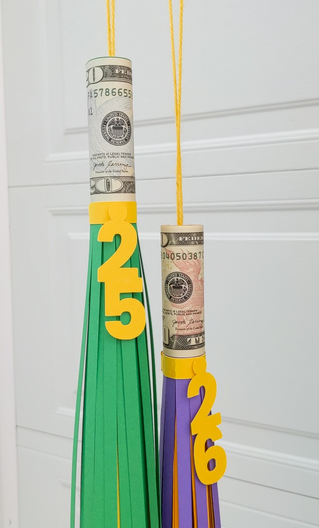 Two DIY paper graduation tassels with money rolled inside