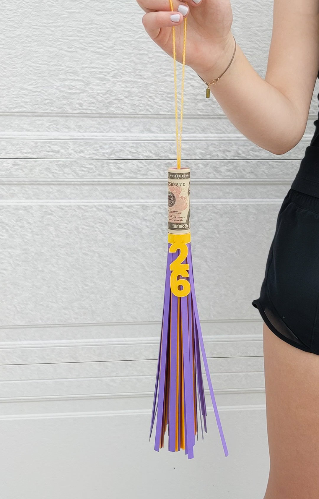 Big paper graduation tassel with money rolled inside for a graduation gift