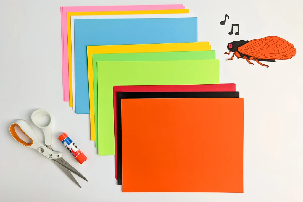 Colorful paper supplies to make a cicada summer bug craft for kids