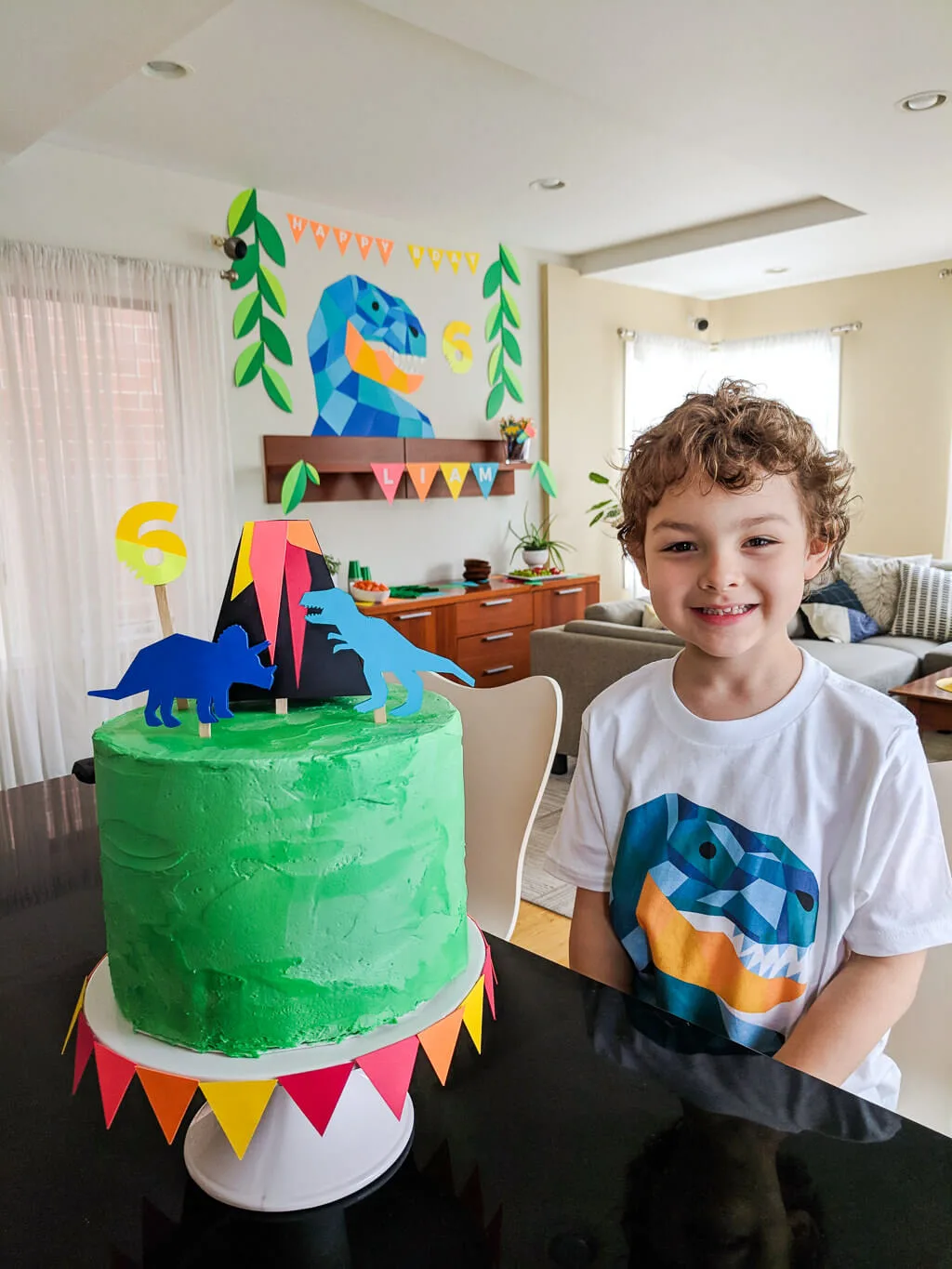 Liam with dinosaur birthday cake Merriment Design