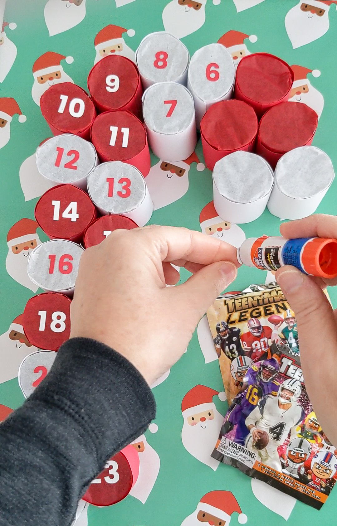 Gluing numbers onto a handmade advent calendar shaped like a candy cane
