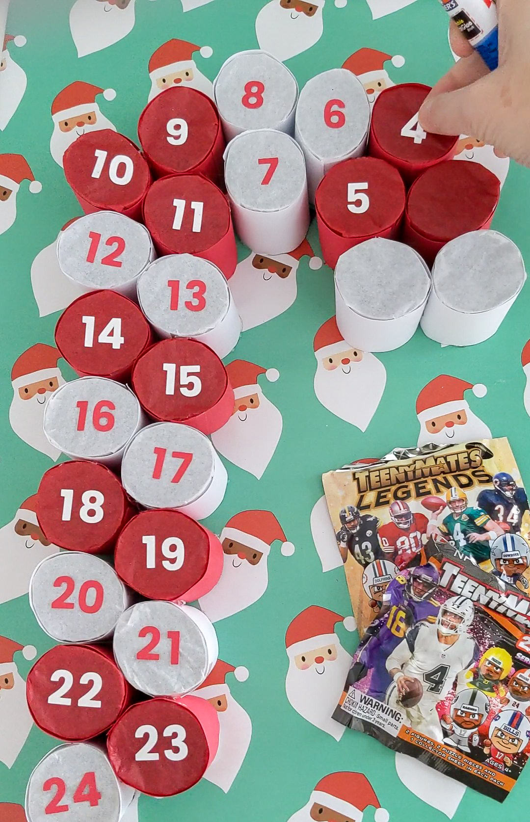 Gluing numbers onto a handmade advent calendar shaped like a candy cane