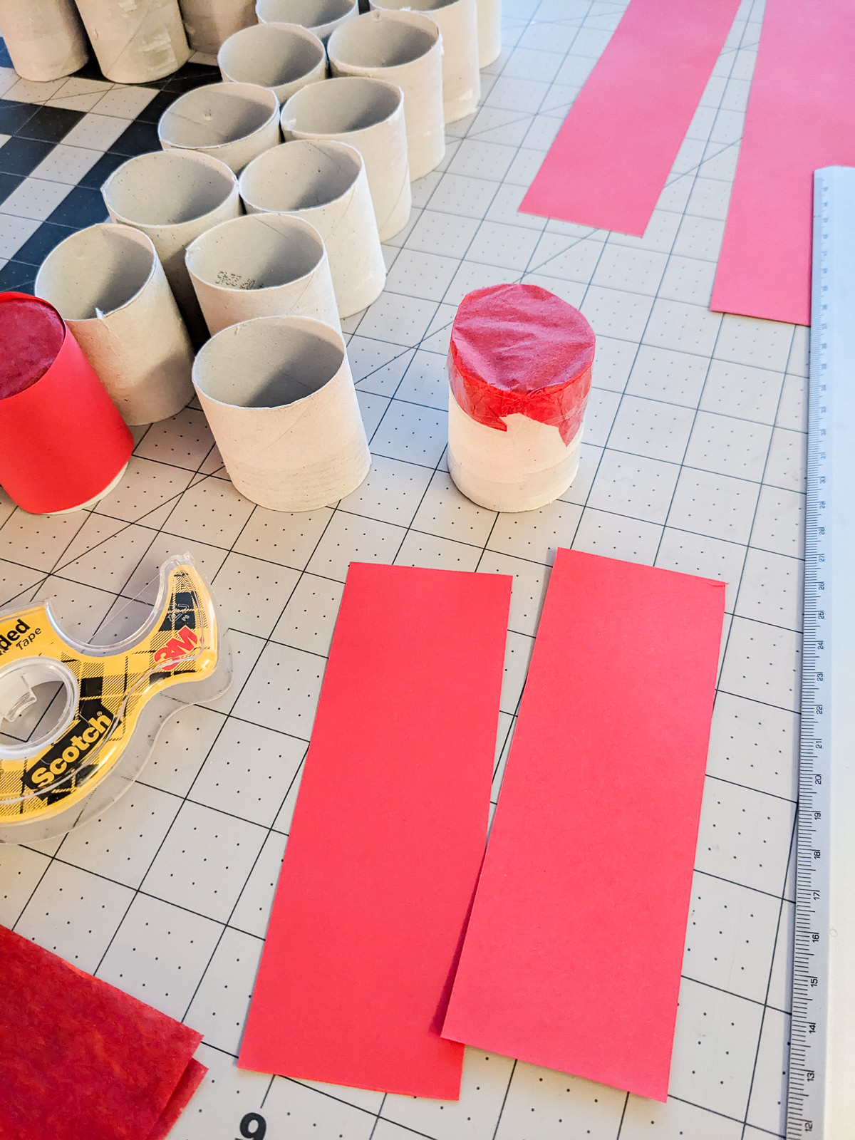 Toilet paper tubes covered in tissue paper and red paper to make a DIY advent calendar