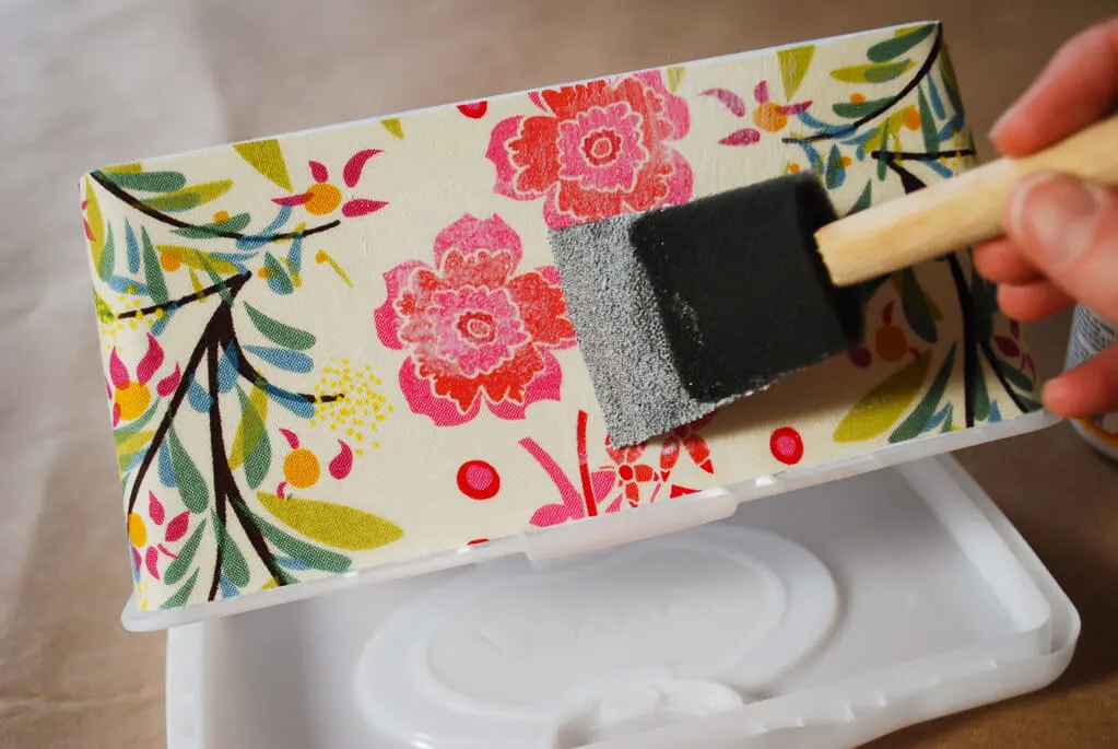 Brushing Mod Podge onto baby wipes box