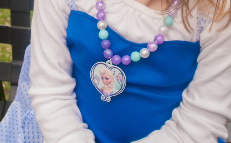 DIY Frozen beaded necklace craft for Frozen birthday parties and Elsa Halloween costumes. Print Elsa onto Shrinky Dinks plastic and bake, then paint beads and string. Such a cute kids activity for summertime, rainy days or a Frozen birthday party!