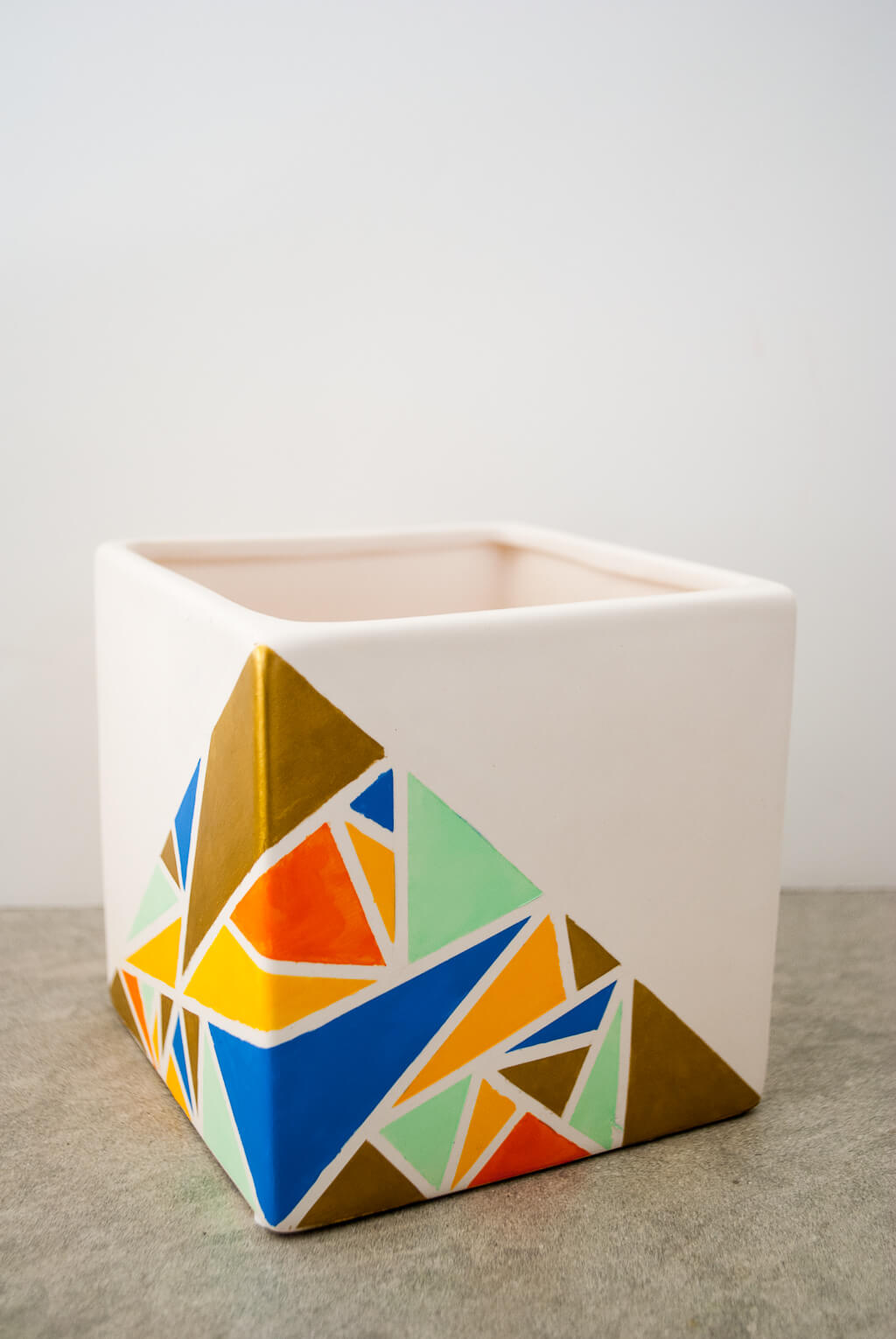 Painted geometric planter with colorful triangles