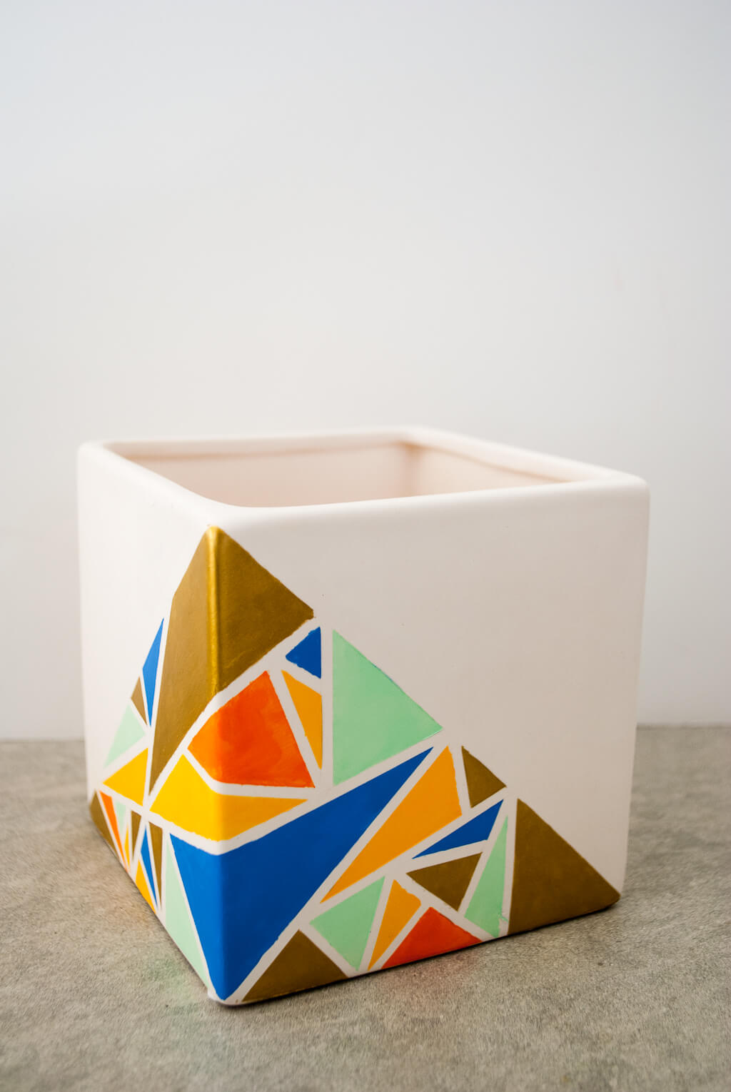 Painted geometric planter with colorful triangles