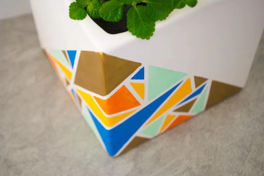 Painted geometric planter with colorful triangles
