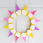 Easy DIY summer ice cream wreath that looks like rays of sunshine! Make it for your front door in less than one hour.