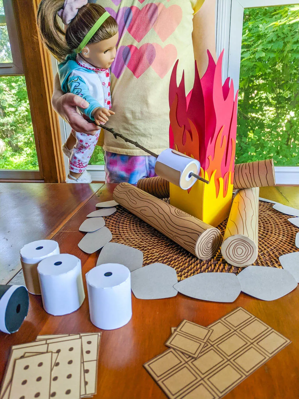 American Girl doll playing with paper campfire and s'mores pretend play set