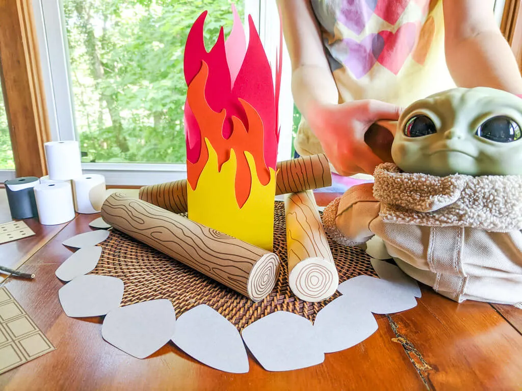 Baby Yoda playing with pretend campfire play set