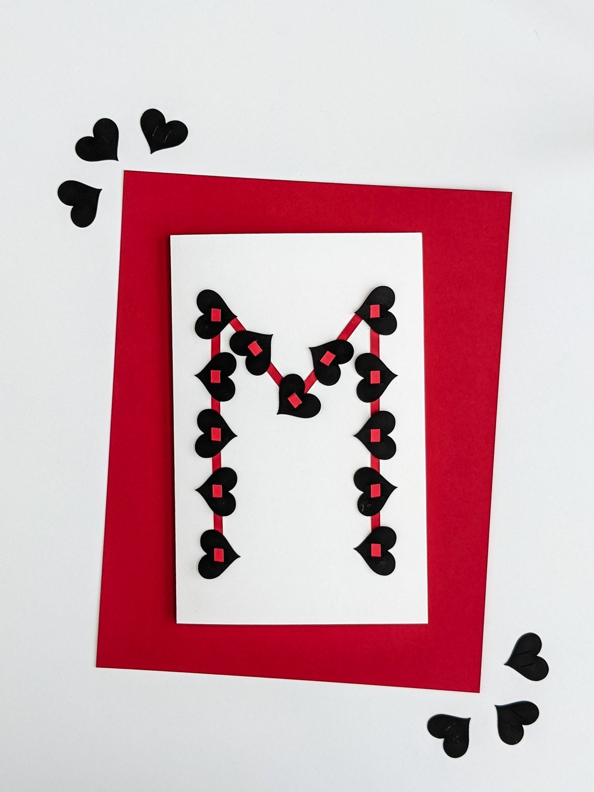 Handmade valentine for teens with black hearts and red strips of their first initial