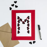 Handmade valentine for teens with black hearts and red strips of their first initial