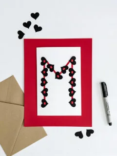 Handmade valentine for teens with black hearts and red strips of their first initial