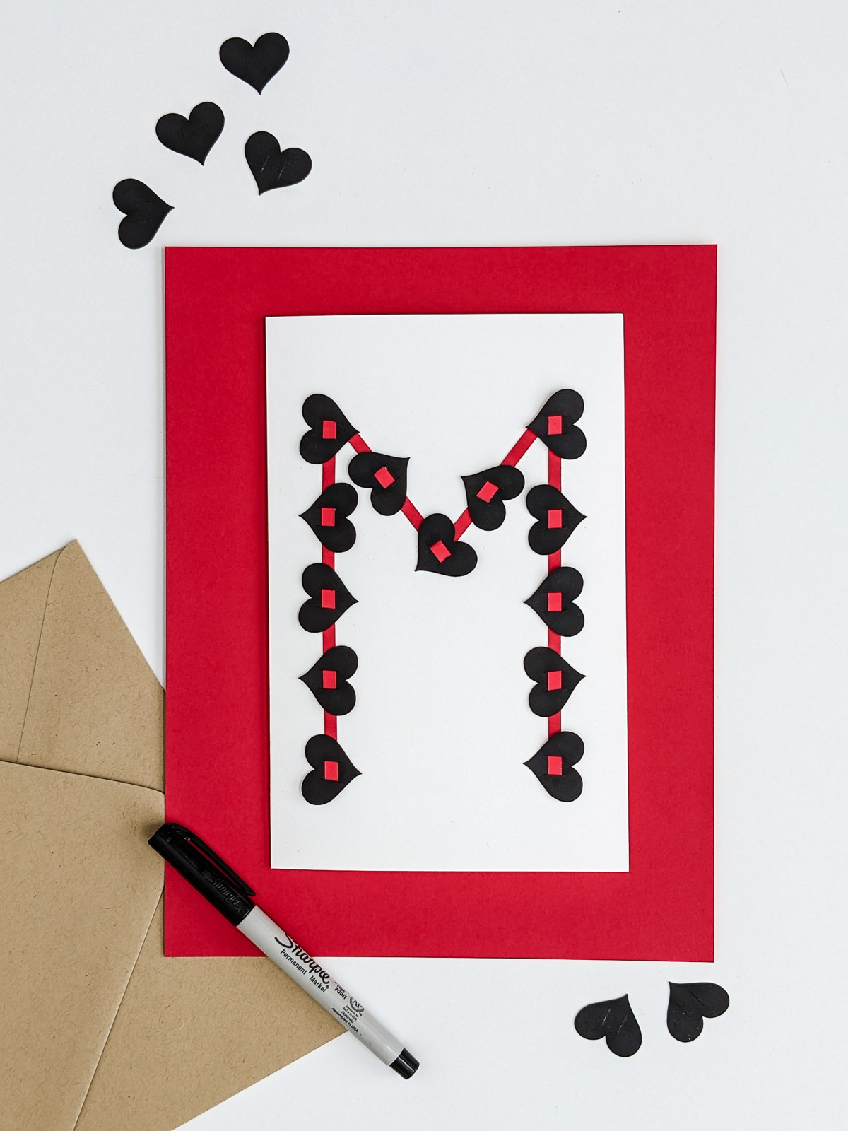 Handmade valentine for teens with black hearts and red strips of their first initial