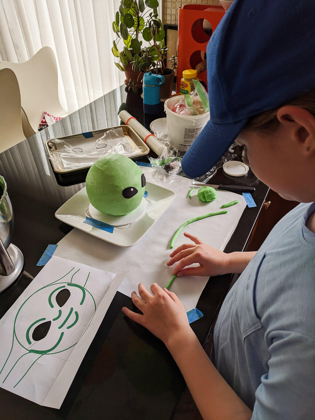 Elise making a Baby Yoda cake. Copyright Merriment Design Co. Do not distribute.