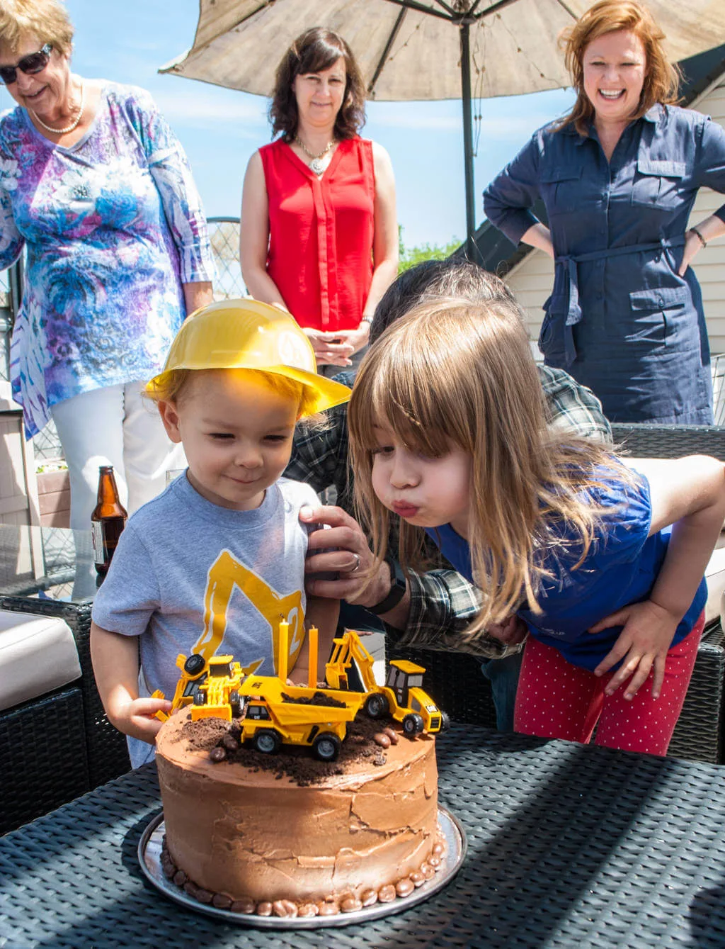 Blowing out candles on construction cake