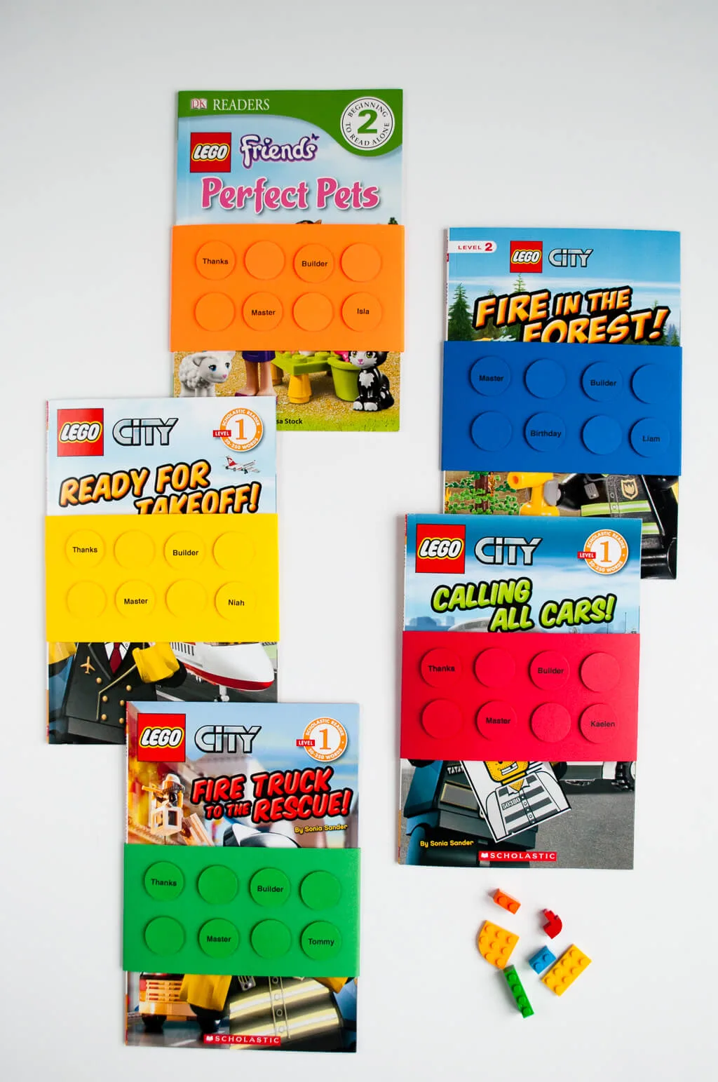 Easy DIY LEGO Birthday Party Favors: Wrap LEGO books with personalized paper LEGO brick book wraps using colored paper and a circle craft punch. It's an easy and useful LEGO birthday party favor idea!