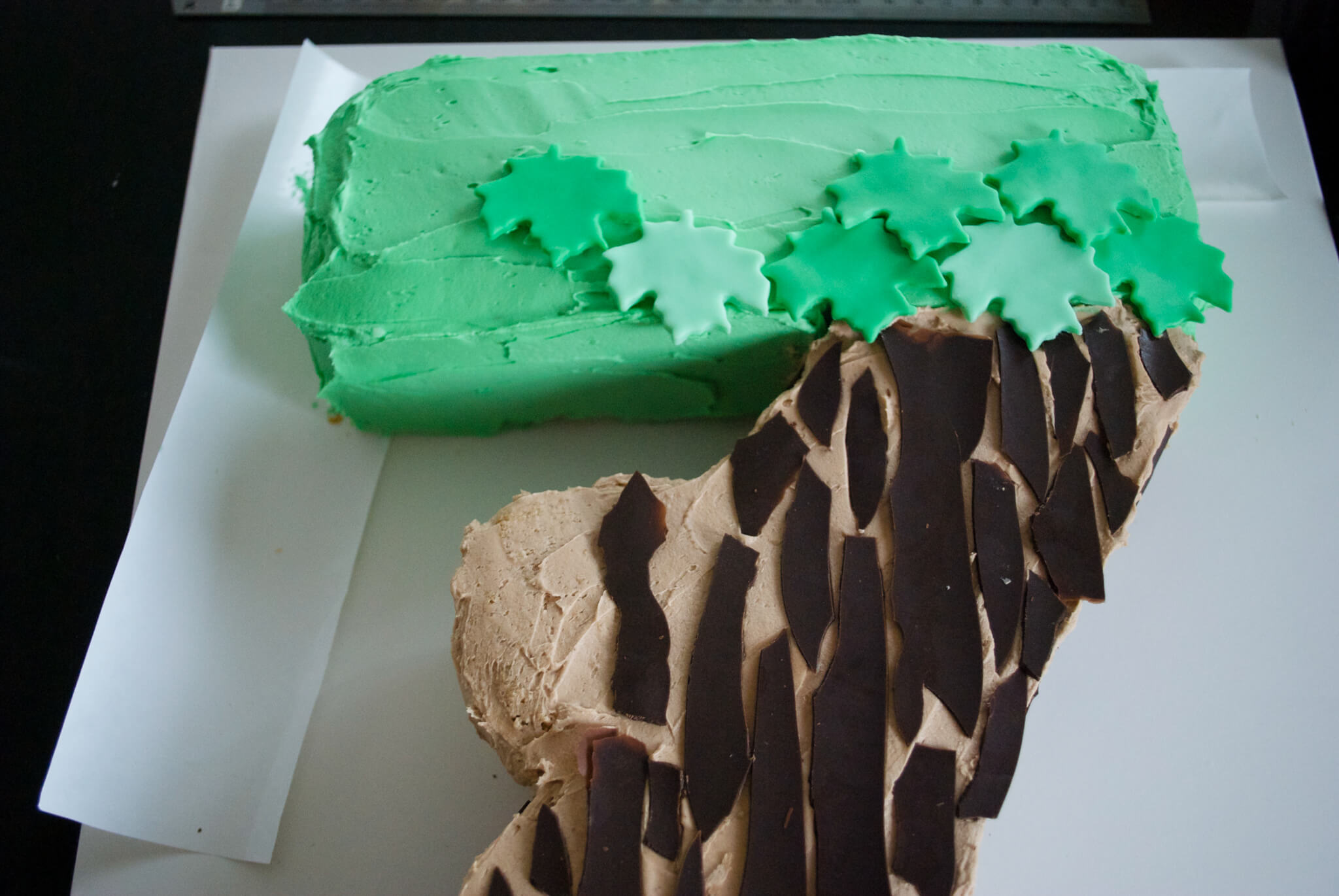 Easy DIY Magic Tree House birthday cake for a Magic Tree House 7th birthday party. Edible tree house and leaves are fondant, bark is chocolate. Get the free printable template to make the tree house and number 7 shaped cake - no special cake pan needed!