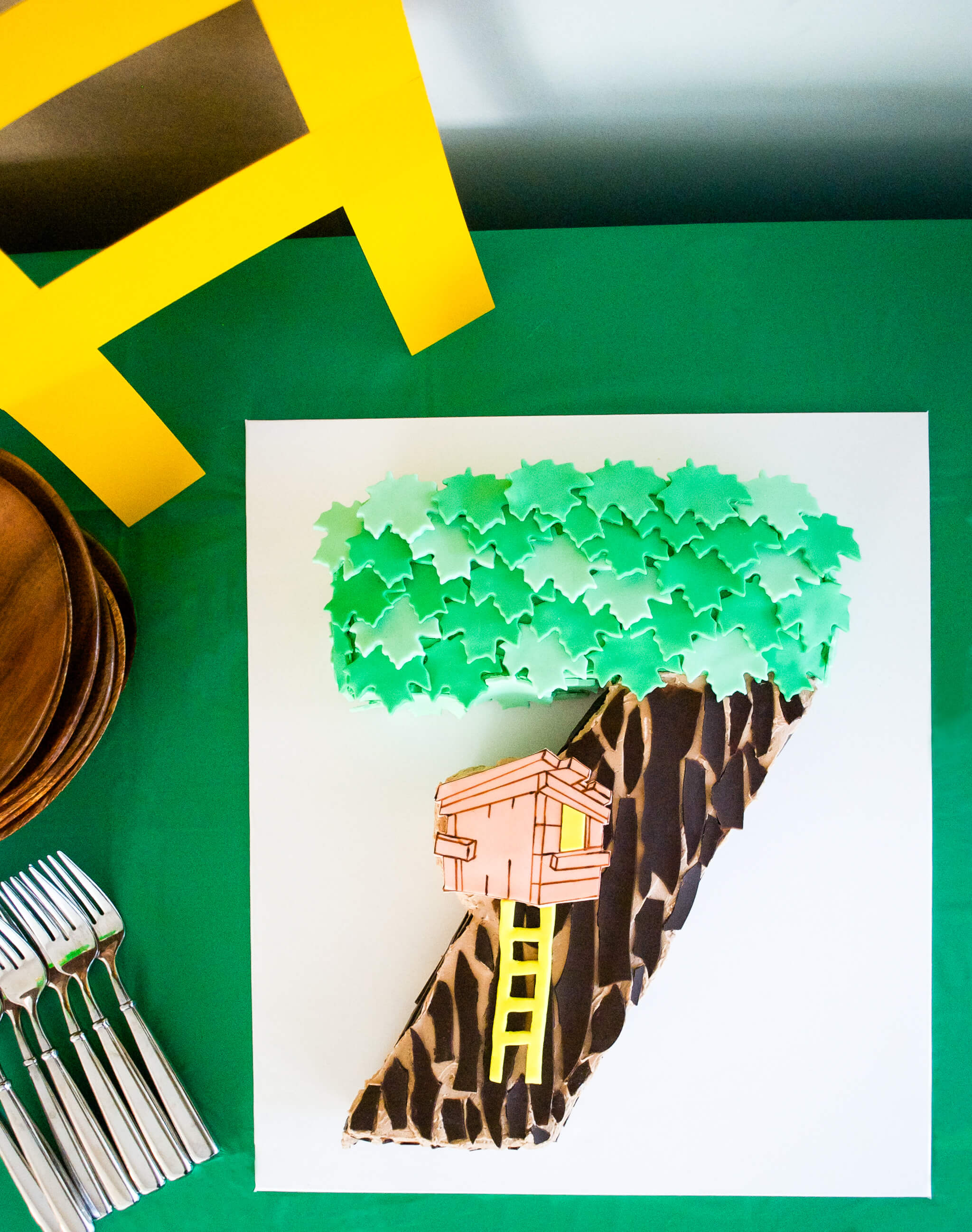 Easy DIY Magic Tree House birthday cake for a Magic Tree House 7th birthday party. Edible tree house and leaves are fondant, bark is chocolate. Get the free printable template to make the tree house and number 7 shaped cake - no special cake pan needed!