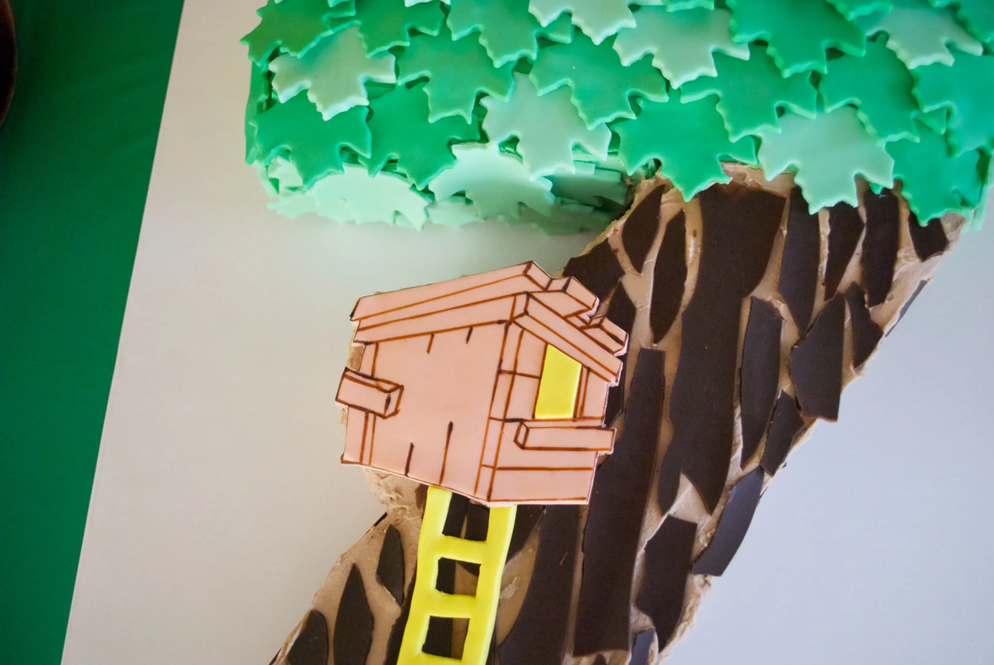 Easy DIY Magic Tree House birthday cake for a Magic Tree House 7th birthday party. Edible tree house and leaves are fondant, bark is chocolate. Get the free printable template to make the tree house and number 7 shaped cake - no special cake pan needed!