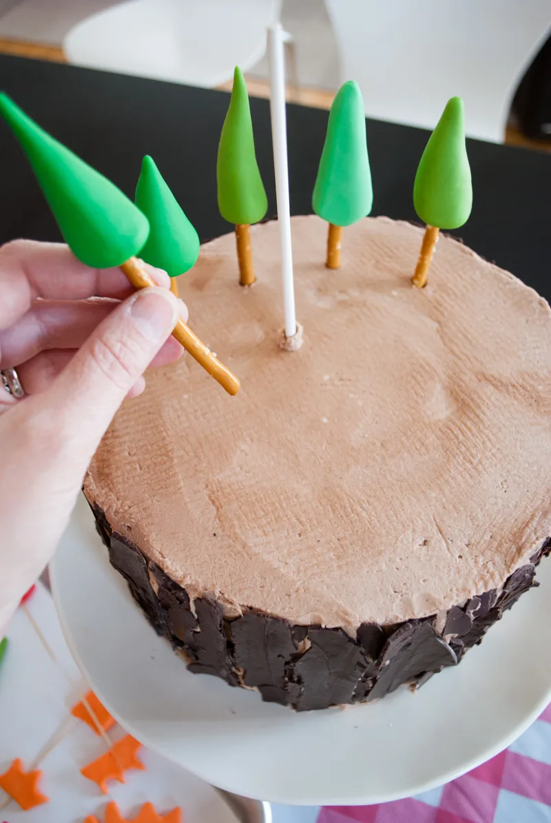 Easy DIY Planes Fire & Rescue Birthday Cake for your little fireman. This cute forest trees and flames cake is simple for beginners. Firemen Dusty, Blaze, Dipper and Windlifter are on their way to put out the forest fire in Piston Peak National Park! A trees birthday cake would be cute for a camping birthday party too.