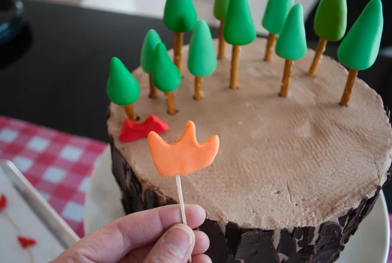 Easy DIY Planes Fire & Rescue Birthday Cake for your little fireman. This cute forest trees and flames cake is simple for beginners. Firemen Dusty, Blaze, Dipper and Windlifter are on their way to put out the forest fire in Piston Peak National Park! A trees birthday cake would be cute for a camping birthday party too.