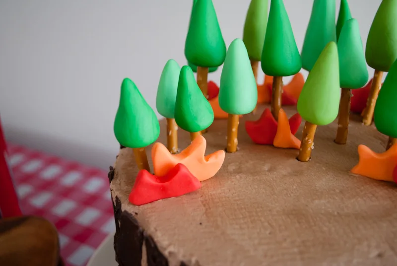 Easy DIY Planes Fire & Rescue Birthday Cake for your little fireman. This cute forest trees and flames cake is simple for beginners. Firemen Dusty, Blaze, Dipper and Windlifter are on their way to put out the forest fire in Piston Peak National Park! A trees birthday cake would be cute for a camping birthday party too.