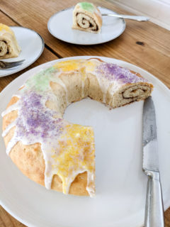 King cake sliced to show cinnamon roll swirl