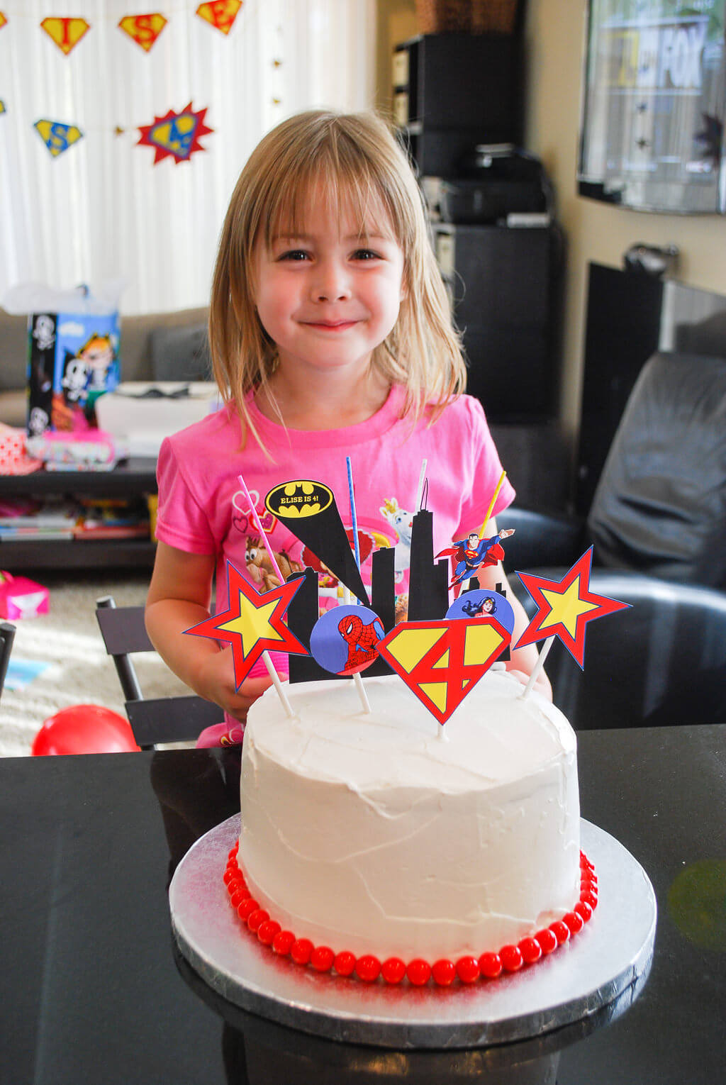 Elise with her Super Hero birthday cake. Copyright Merriment Design Co. Do not reuse without written permission.