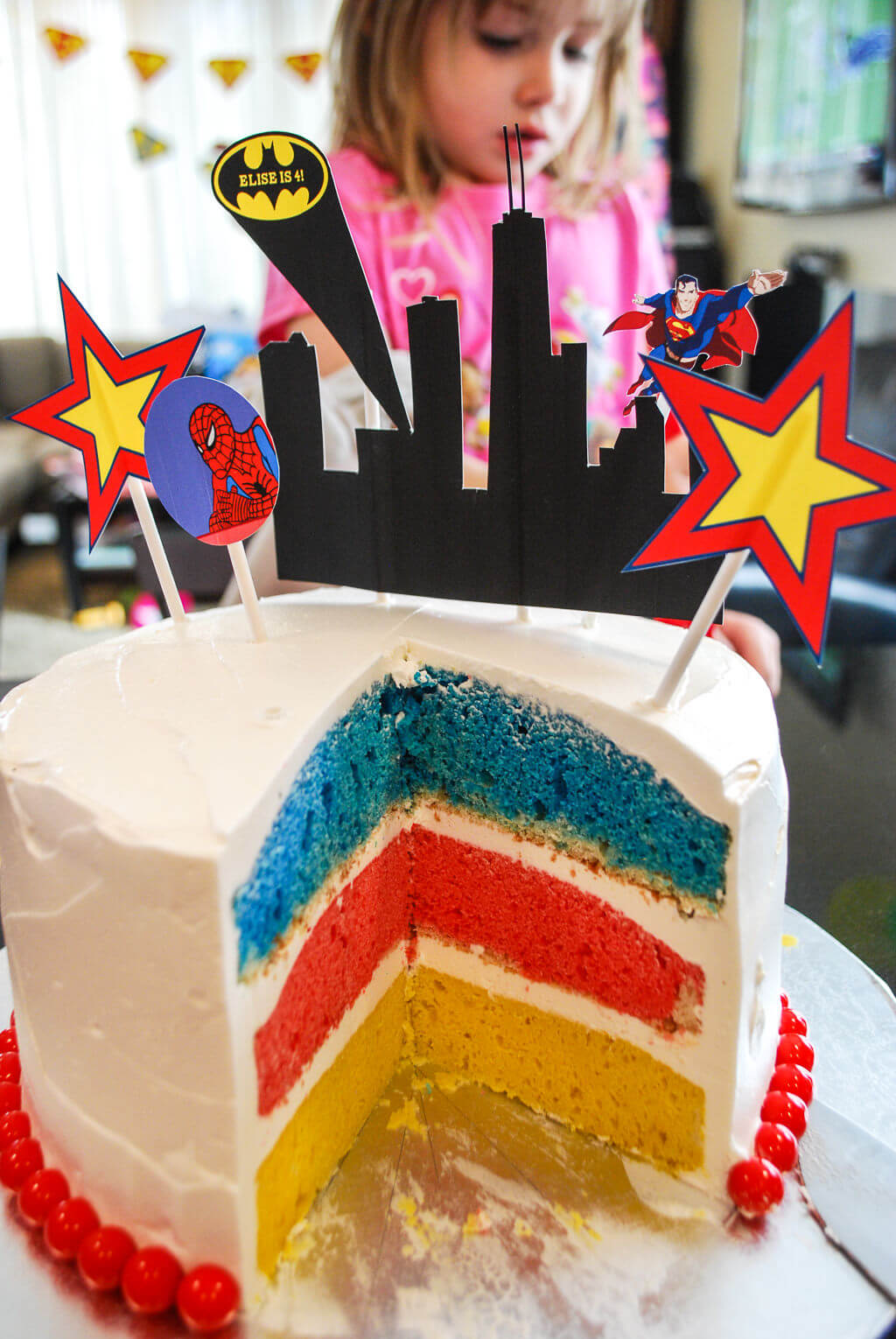 Superhero cake with colorful cake layers in yellow, red, and blue