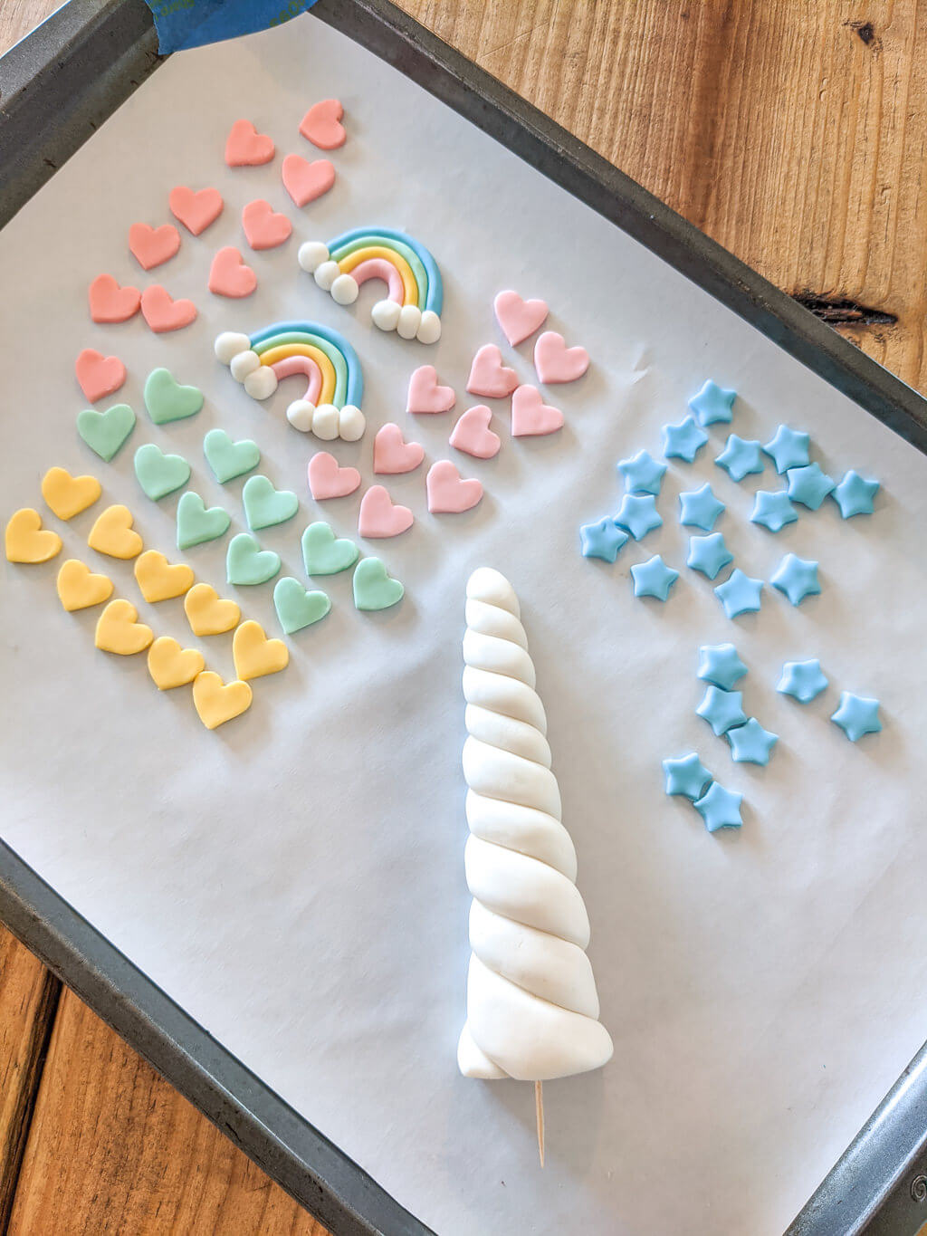 fondant stars, rainbows, and unicorn horn cake toppers for a unicorn birthday cake