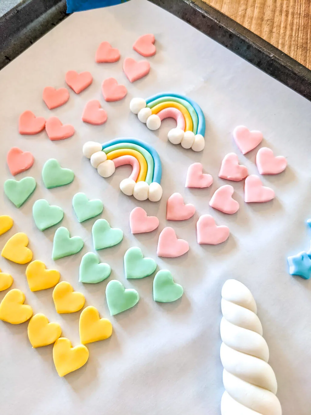 fondant stars, rainbows, and unicorn horn cake toppers for a unicorn birthday cake