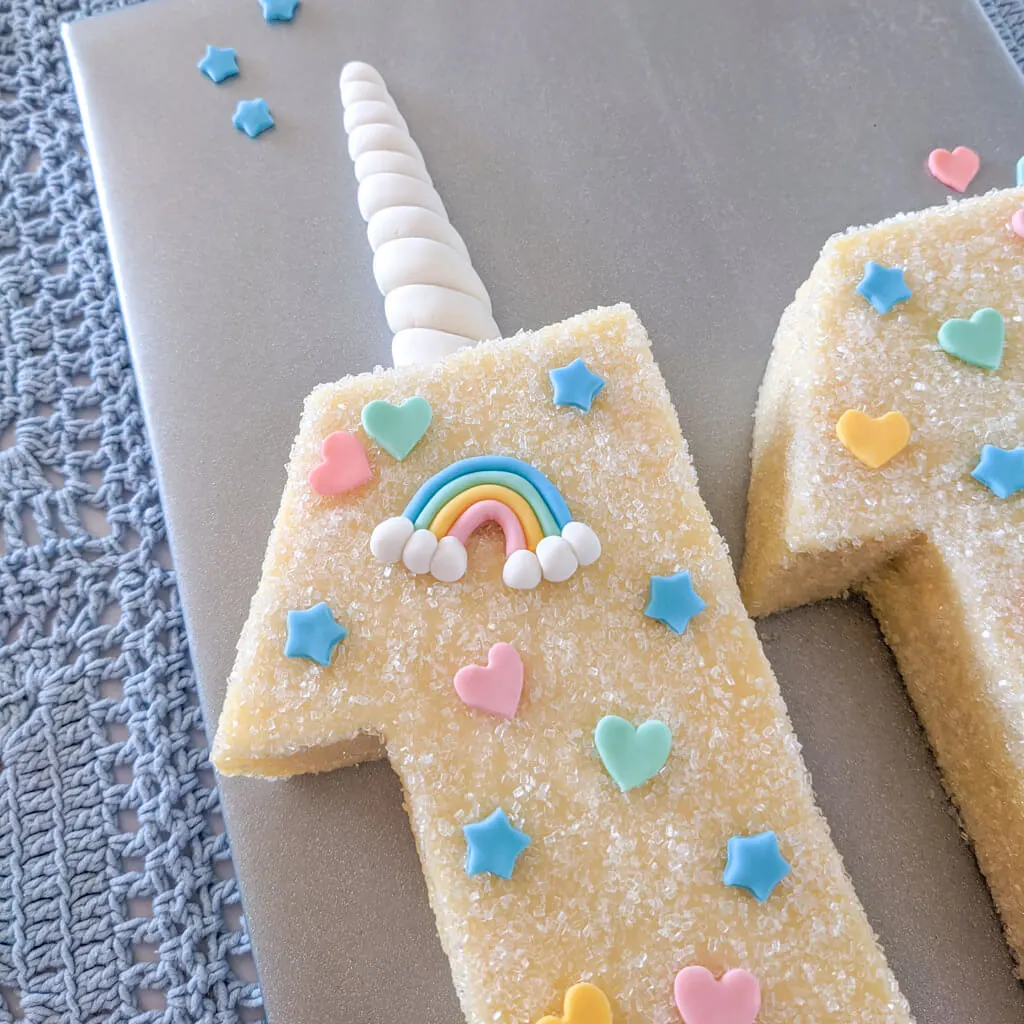 Unicorn cake with fondant horn, rainbows, stars, and hearts