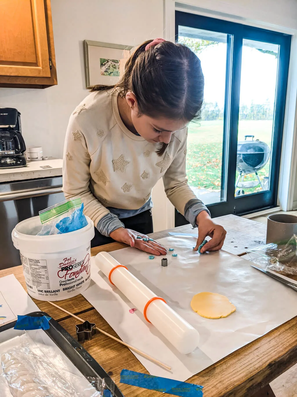 Elise making fondant cake toppers for a unicorn and rainbows birthday cake. Copyright Merriment Design Co. Written permission required for use.